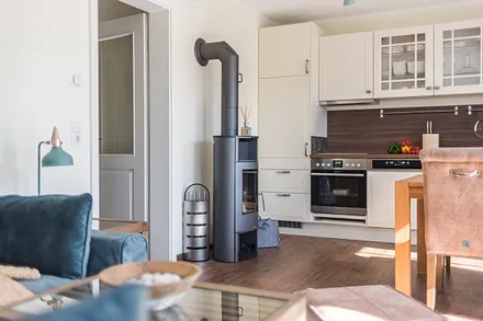 Wohnbereich mit Couch, Couchtisch, Leselampe, Sideboard, Smart-TV, DAB Radio, Blu Ray Player sowie durchgängige Fensterfront mit fantastischen Panorama- und Meerblick