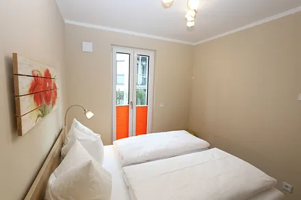 Schlafzimmer mit Doppelbett (1,60 m x 2,00 m), 2 Nachttischablagen, Kleiderablage und Drehtürenschrank