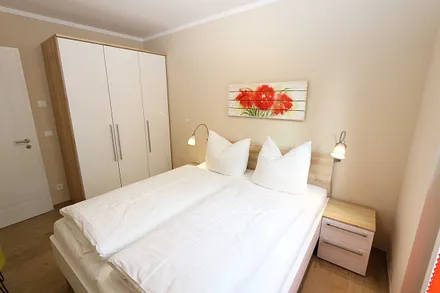 Schlafzimmer mit Doppelbett (1,60 m x 2,00 m), 2 Nachttischablagen, Kleiderablage und Drehtürenschrank