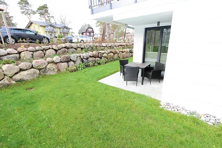 bestuhlte Terrasse (Süd) mit Sonnenschirm und kleinem Gartenanteil