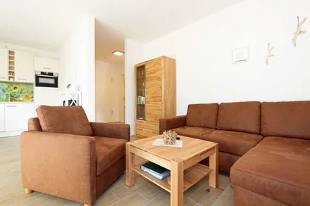 Wohnbereich mit Eckcouch, Couchtisch, Sessel, Vitrine, Smart-TV mit integriertem Radio, USB-Anschluss und Bluetooth