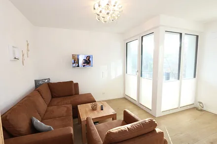 Wohnbereich mit Eckcouch, Couchtisch, Sessel, Vitrine, Smart-TV mit integriertem Radio, USB-Anschluss und Bluetooth