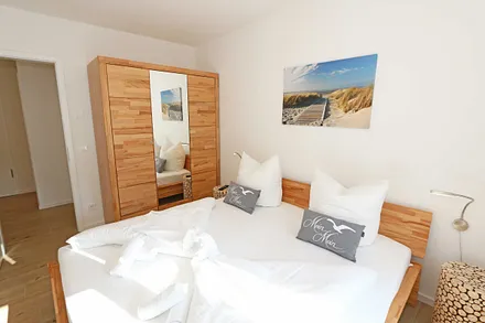 Schlafzimmer mit Doppelbett (1,80 m x 2,00 m), verstellbare Lattenroste, Nachttischablagen, Kleiderschrank mit Spiegelfront, Verdunklungsmöglichkeiten, Plissees sowie Insektenschutzgitter & Smart TV