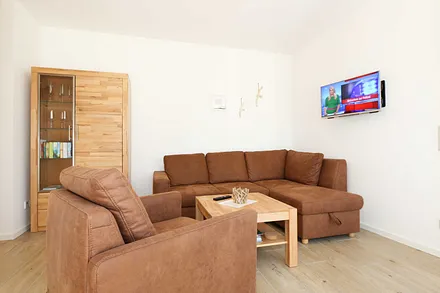 Wohnzimmer mit TV, Couch und Sessel