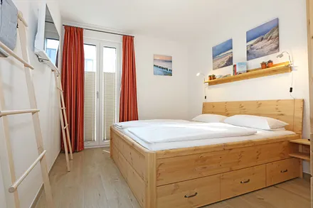 Schlafzimmer mit Doppelbett (1,80 m x 2.00 m), verstellbare Lattenroste, Nachttischablagen, Ganzkörperspiegel, Kleiderablage, geräumiger Kleiderschrank, Smart-TV sowie Verdunklungs-Vorhängen