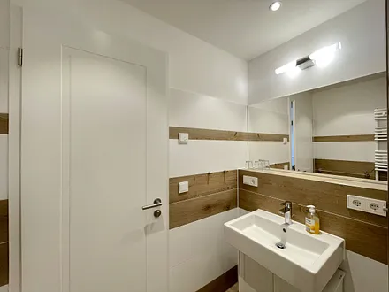 Badezimmer mit ebenerdiger Regen-Dusche, Fön, WC, Waschtisch und Sauna