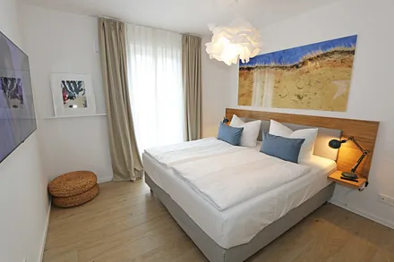 Schlafzimmer mit komfortablem Boxspringbett (1,80 m x 2,00 m), durchgehendem Topper, Nachttischablagen und großem Kleiderschrank sowie Smart-TV