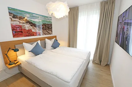 Schlafzimmer mit komfortablem Boxspringbett (1,80 m x 2,00 m), durchgehendem Topper, Nachttischablagen und großem Kleiderschrank sowie Smart-TV