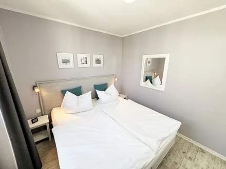 Schlafzimmer mit Boxspringbett und komfortablem Topper
