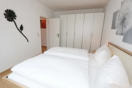 Schlafzimmer mit Doppelbett (1,80 m x 2,00 m), Nachttischablagen, Kleiderschrank sowie einen weiteren Smart-TV welcher aber nur zum Streamen genutzt werden kann