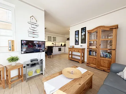 gemütlicher Wohnbereich mit Ecksofa, Glasvitrine und Smart-TV