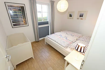Schlafzimmer mit einem Doppelbett (1,80 m x 2,00 m), Qualitäts- Latexmatratzen, verstellbarem Lattenrost, Kleiderschrank und Verdunklungsplissees 