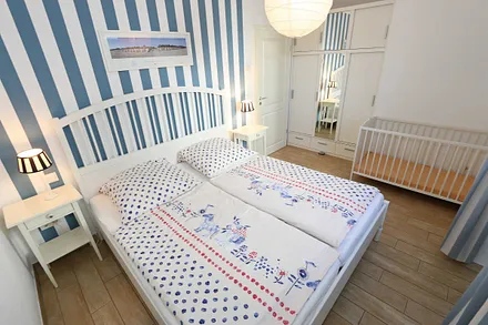 Schlafzimmer mit einem Doppelbett (1,80 m x 2,00 m), Qualitäts- Latexmatratzen, verstellbarem Lattenrost, Kleiderschrank und Verdunklungsplissees 