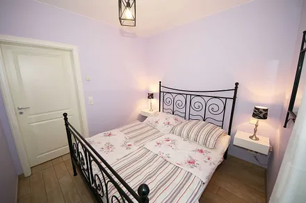 Schlafzimmer mit einem Doppelbett (1,60 m x 2,00 m), Qualitäts- Latexmatratzen, verstellbarem Lattenrost, Kleiderschrank und Verdunklungsplissees 