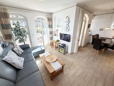 gemütlicher Wohnbereich mit Ecksofa, Glasvitrine und Smart-TV