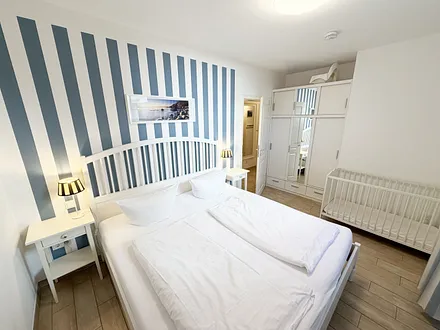 1. Schlafzimmer mit Doppelbett, Kleiderschrank und Nachttischablagen