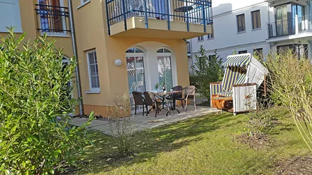 überdachte und bestuhlte Terrasse (Nordost) mit Strandkorb und Blick auf den Kurpark - vom Wohnbereich begehbar