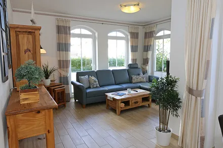 gemütlicher Wohnbereich mit Ecksofa, Glasvitrine mit Büchern und Gesellschaftsspielen, Leselampe, Smart-TV mit Blu Ray-Player, DAB Radio und CD-Player