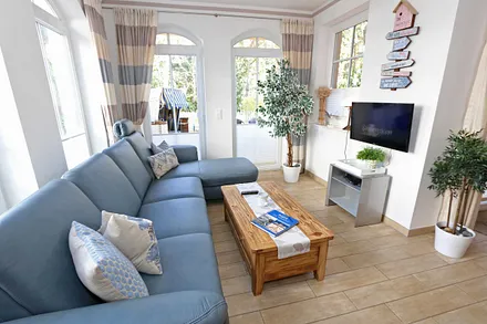 gemütlicher Wohnbereich mit Ecksofa, Glasvitrine mit Büchern und Gesellschaftsspielen, Leselampe, Smart-TV mit Blu Ray-Player, DAB Radio und CD-Player