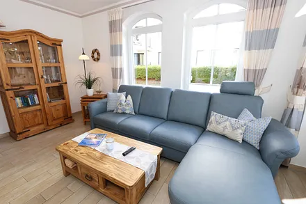 gemütlicher Wohnbereich mit Ecksofa, Glasvitrine mit Büchern und Gesellschaftsspielen, Leselampe, Smart-TV mit Blu Ray-Player, DAB Radio und CD-Player