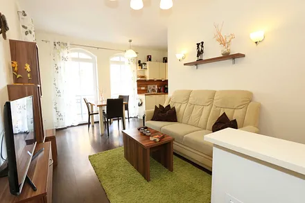 Wohnzimmer (20 m²) mit einer Sitzcouch, Tisch, Smart-TV und Blu-Ray-Player