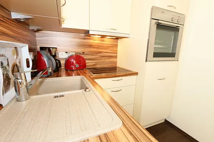 integrierte Küchenzeile mit Geschirrspüler, Keramikspüle, Ceranfeld, Backofen, Kühlschrank mit Gefrierfach und diversen Küchenutensilien