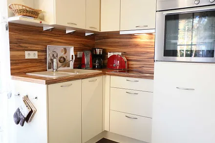 integrierte Küchenzeile mit Geschirrspüler, Keramikspüle, Ceranfeld, Backofen, Kühlschrank mit Gefrierfach und diversen Küchenutensilien