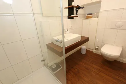 hochwertiges Badezimmer mit Dusche, WC, Fön, Handtuchheizkörper sowie einem exklusiven Waschtisch mit passenden Wandfliesen von Villeroy + Boch