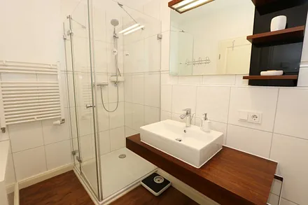 hochwertiges Badezimmer mit Dusche, WC, Fön, Handtuchheizkörper sowie einem exklusiven Waschtisch mit passenden Wandfliesen von Villeroy + Boch