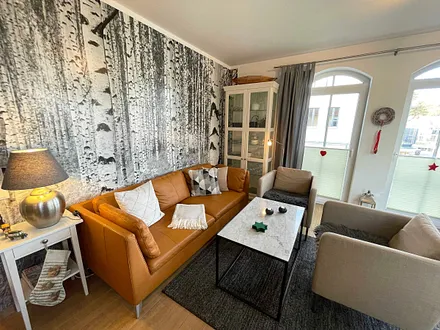 Wohnzimmer mit gemütlicher Sitzecke, Leselampe, Smart-TV, DVD-Player und Telefon