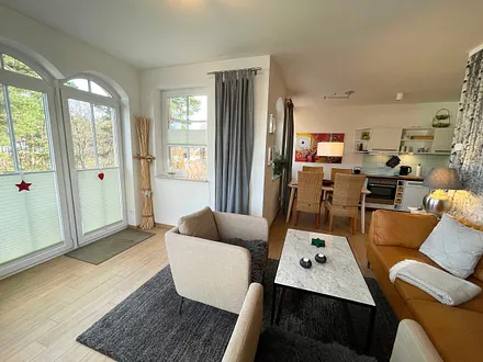 Wohnzimmer mit gemütlicher Sitzecke, Leselampe, Smart-TV, DVD-Player und Telefon