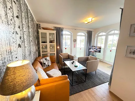 Wohnzimmer mit gemütlicher Sitzecke, Leselampe, Smart-TV, DVD-Player und Telefon