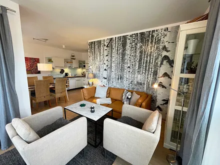 Wohnzimmer mit gemütlicher Sitzecke, Leselampe, Smart-TV, DVD-Player und Telefon