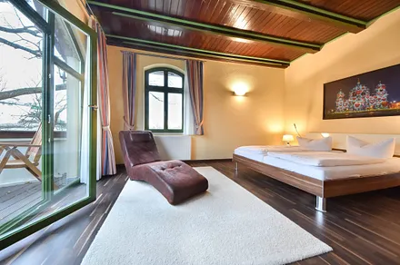 Schlafzimmer mit Relaxliege und Balkonzugang 