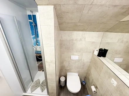 innenliegendes Badezimmer mit WC, Dusche (80 m x 75 m), Waschtisch mit Ablagemöglichkeit, Fön, Kosmetikspiegel, großem Wandspiegel und Handtuchheizkörper