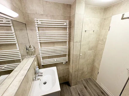 innenliegendes Badezimmer mit WC, Dusche (80 m x 75 m), Waschtisch mit Ablagemöglichkeit, Fön, Kosmetikspiegel, großem Wandspiegel und Handtuchheizkörper