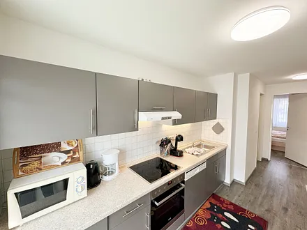 Küchenzeile mit 4 Zonencerankochfeld, Geschirrspüler, Backofen, Kühlschrank mit Gefrierfach, Toaster, Mikrowelle, Wasserkocher, Kaffeemaschine sowie Dolce Gusto Kapselmaschine