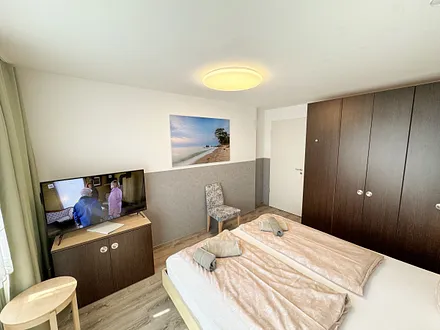 Wohn/Schlafbereich mit 43 Zoll Smart TV,Doppelbett mit Einzelmatratzen (1,80 m x 2,00 m),Nachttischablagen mit Leselampen,geräumigen Kleiderschrank mit Safe,Sideboard mit Mini-Stereoanlage