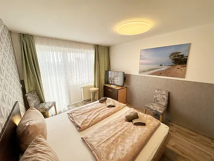 Wohn/Schlafbereich mit 43 Zoll Smart TV,Doppelbett mit Einzelmatratzen (1,80 m x 2,00 m),Nachttischablagen mit Leselampen,geräumigen Kleiderschrank mit Safe,Sideboard mit Mini-Stereoanlage