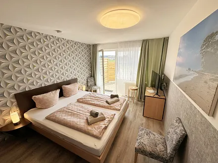 Wohn/Schlafbereich mit 43 Zoll Smart TV,Doppelbett mit Einzelmatratzen (1,80 m x 2,00 m),Nachttischablagen mit Leselampen,geräumigen Kleiderschrank mit Safe,Sideboard mit Mini-Stereoanlage