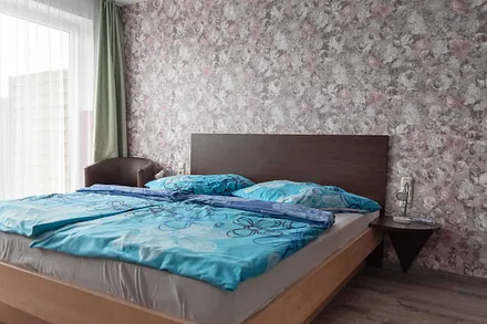 Wohn/Schlafbereich mit 43 Zoll Smart TV, hochwertigen Teppich, Doppelbett mit Einzelmatratzen (1,80 m x 2,00 m), geräumiger Kleiderschrank mit Safe, Sideboard mit Mini-Stereoanlage mit CD-Player