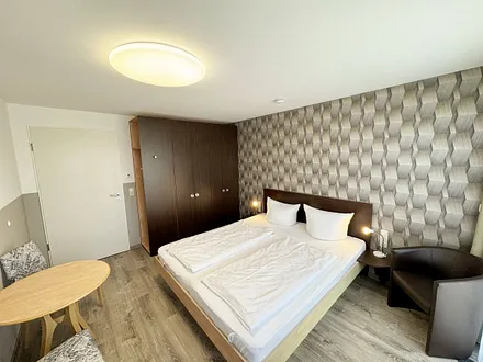 Wohn/Schlafbereich mit 43 Zoll Smart TV,Doppelbett mit Einzelmatratzen (1,80 m x 2,00 m), Nachttischablagen mit Leselampen, geräumiger Kleiderschrank mit Safe, Sideboard mit Mini-Stereoanlage