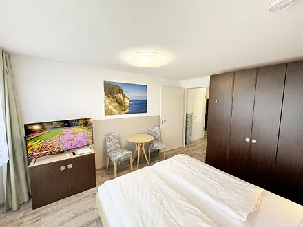 Wohn/Schlafbereich mit 43 Zoll Smart TV,Doppelbett mit Einzelmatratzen (1,80 m x 2,00 m), Nachttischablagen mit Leselampen, geräumiger Kleiderschrank mit Safe, Sideboard mit Mini-Stereoanlage