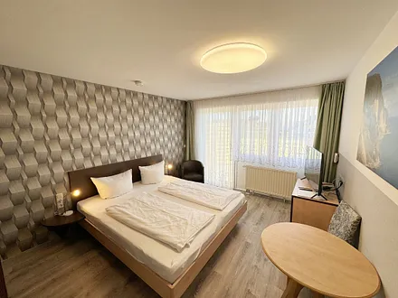 Wohn/Schlafbereich mit 43 Zoll Smart TV,Doppelbett mit Einzelmatratzen (1,80 m x 2,00 m), Nachttischablagen mit Leselampen, geräumiger Kleiderschrank mit Safe, Sideboard mit Mini-Stereoanlage