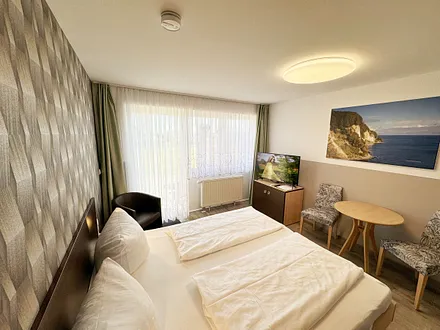 Wohn/Schlafbereich mit 43 Zoll Smart TV,Doppelbett mit Einzelmatratzen (1,80 m x 2,00 m), Nachttischablagen mit Leselampen, geräumiger Kleiderschrank mit Safe, Sideboard mit Mini-Stereoanlage