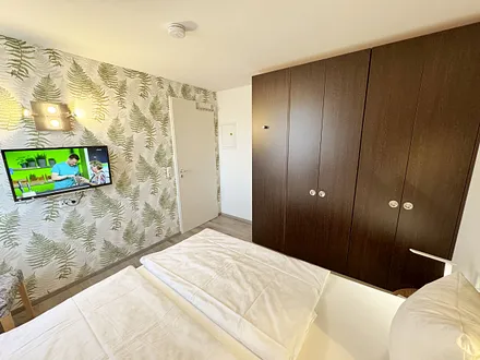 Schlafzimmer mit Doppelbett ( 2 x 0,90 m x 2,00 m ), Nachttischablagen mit Leselampen, Kleiderschrank mit Safe und Verdunklungsgardinen sowie Insektenschutzgitter