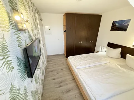 Schlafzimmer mit Doppelbett ( 2 x 0,90 m x 2,00 m ), Nachttischablagen mit Leselampen, Kleiderschrank mit Safe und Verdunklungsgardinen sowie Insektenschutzgitter