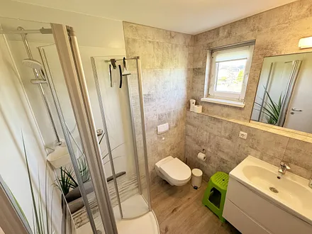 Badezimmer mit WC, große Halbrunddusche (0,90 m x 0,90 m), Waschtisch mit Schubladen, Fön, großem Wandspiegel, Kosmetikspiegel, Handtuchheizkörper