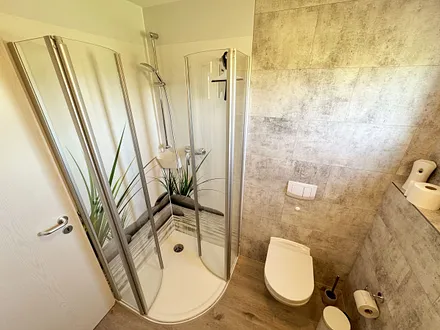 Badezimmer mit WC, große Halbrunddusche (0,90 m x 0,90 m), Waschtisch mit Schubladen, Fön, großem Wandspiegel, Kosmetikspiegel, Handtuchheizkörper