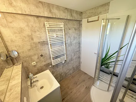 Badezimmer mit WC, große Halbrunddusche (0,90 m x 0,90 m), Waschtisch mit Schubladen, Fön, großem Wandspiegel, Kosmetikspiegel, Handtuchheizkörper